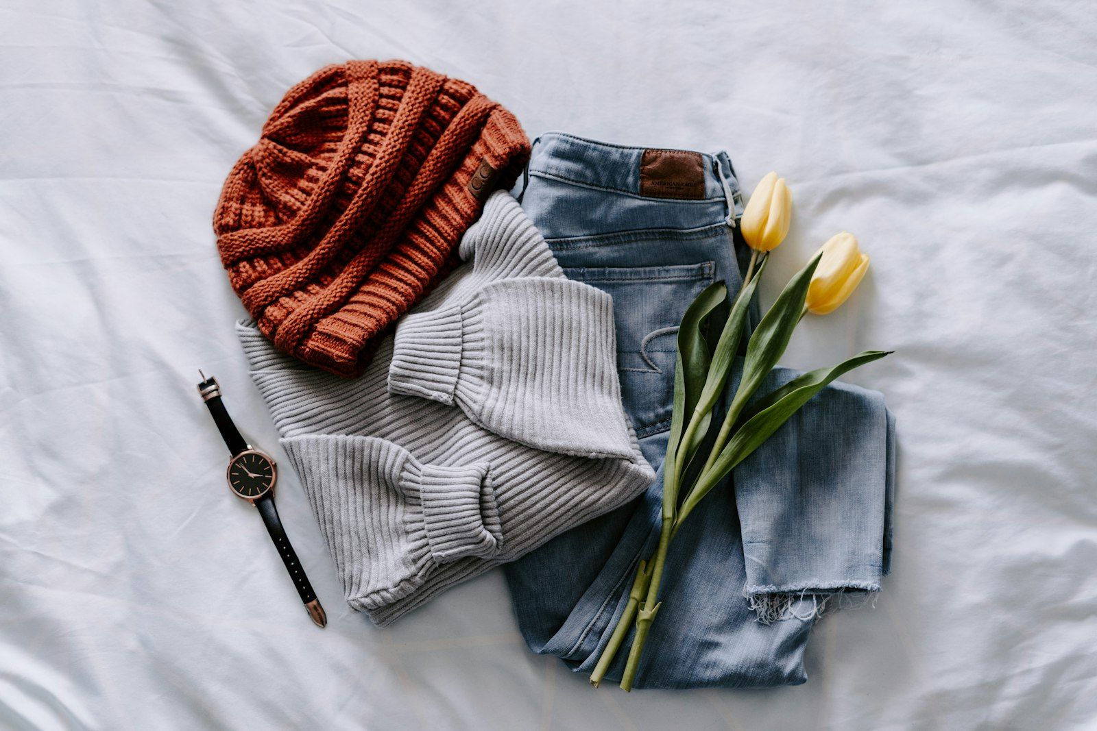 Knitwear, denim and accessories flat lay